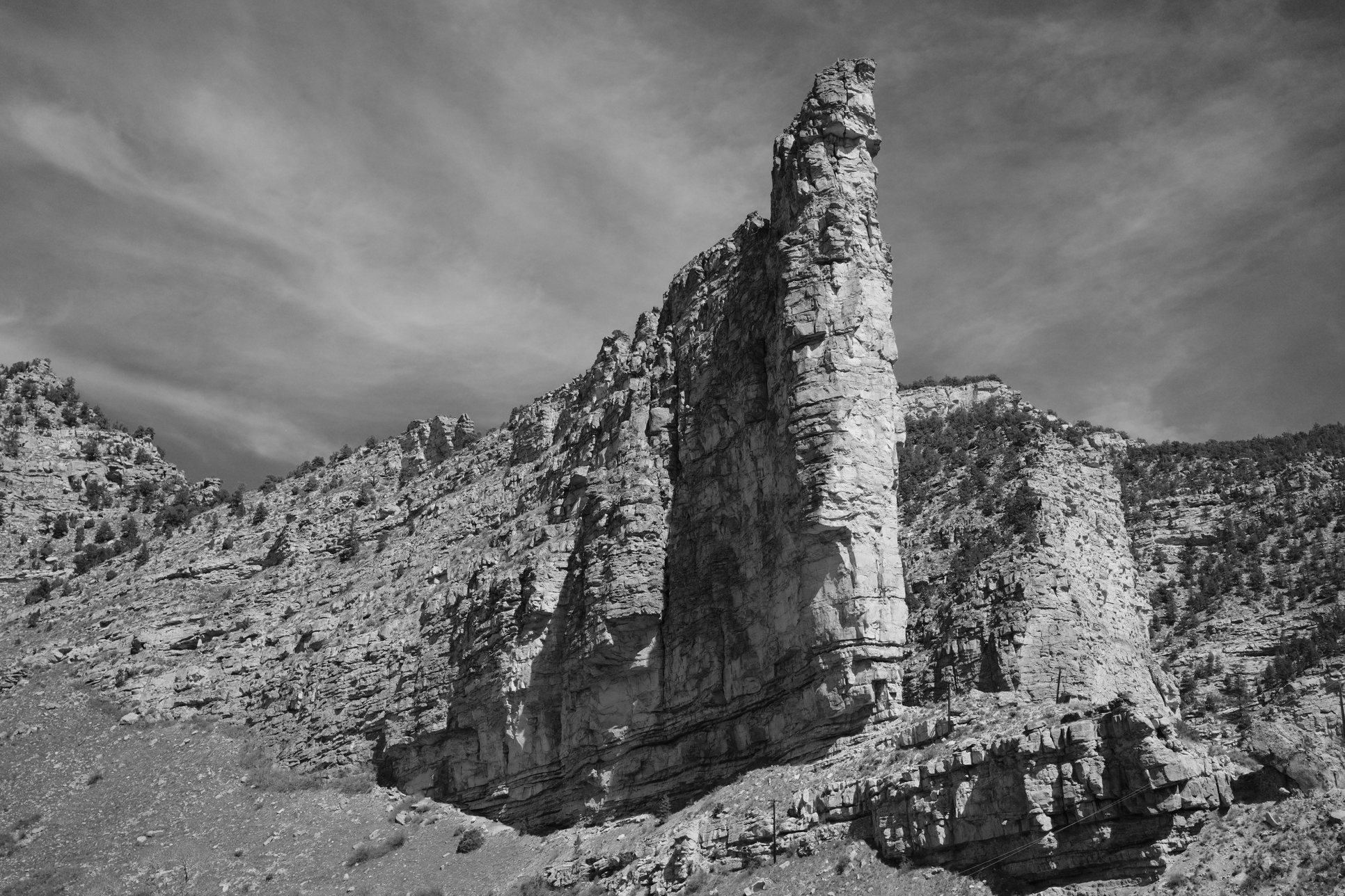 Took this in the car and it's fantastic. I don't know why but I like it. Partly black and white adding something, partly that we were in motion and I got it, partly that this cliff face looks just looks imposing. You can see the power lines along the bottom right that put it in perspective. Just love this photo.